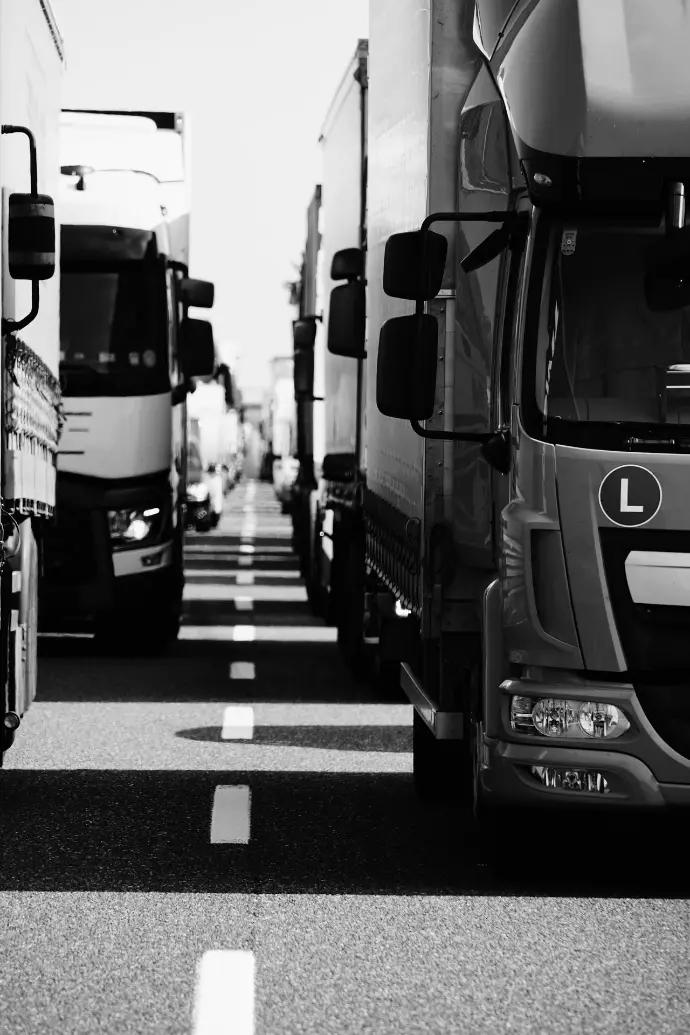 A line of semi trucks in a traffic jam on a highway